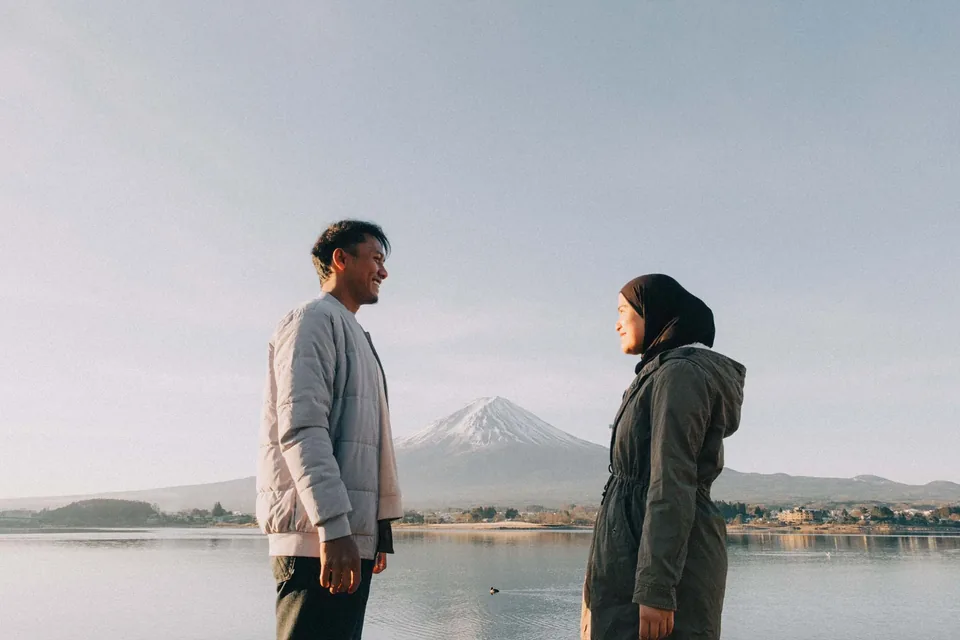 Couple facing one another with Mount Fuji in the background