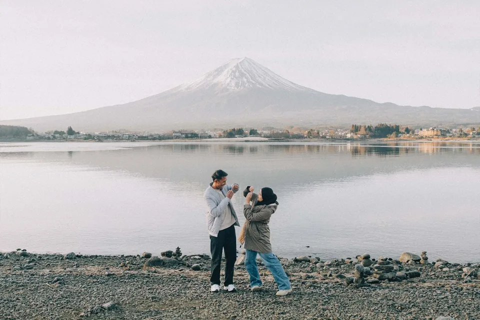 Couple holding hands at golden hour with Mount Fuji behind them