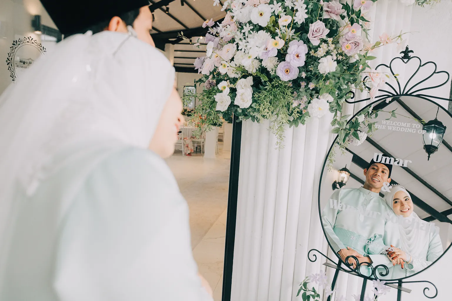 Malay wedding couple walking through a garden reception